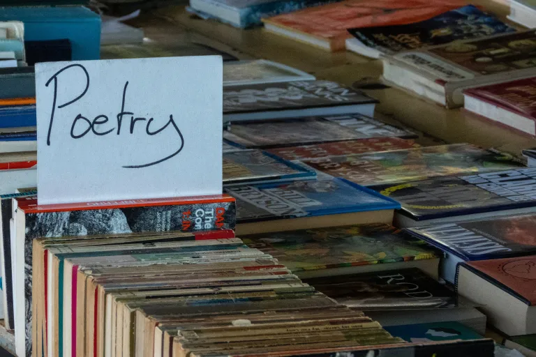 Books for sale with sign saying poetry